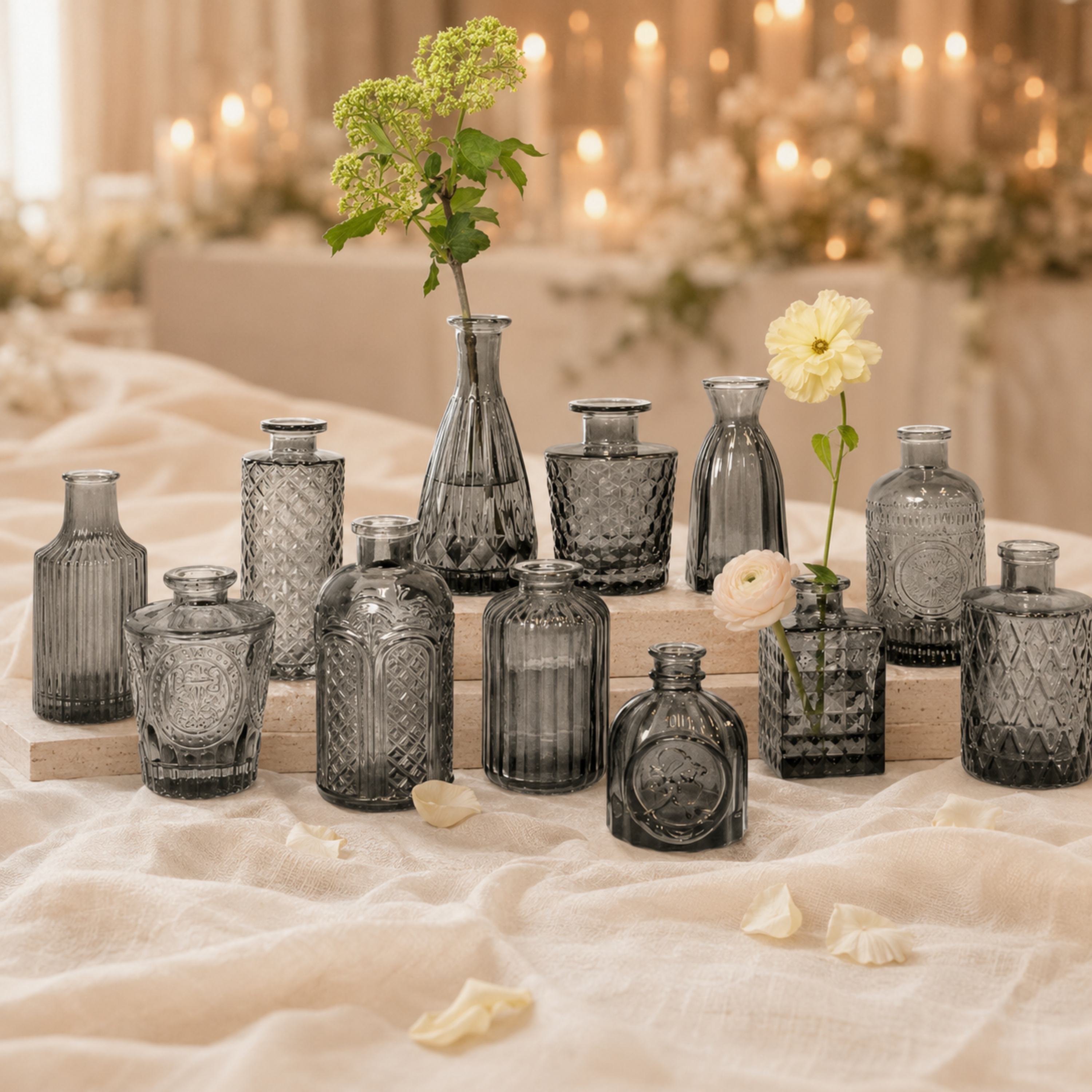 Vintage black bud vase set with small floral stems arranged on a neutral tablecloth
