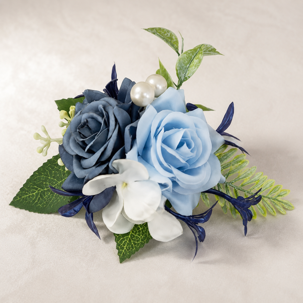 Dusty blue and navy rose boutonniere with white florals, pearls, and greenery on a neutral background