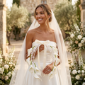 Bride holding white calla lily pearl wedding bouquet with ribbon during outdoor ceremony
