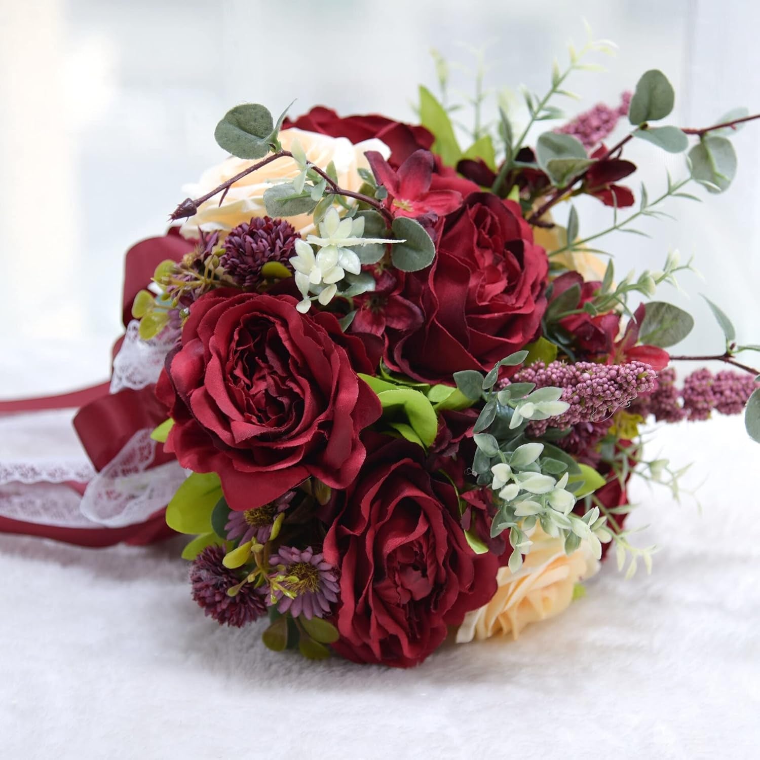 Burgundy bridal bouquet with deep red flowers and ivory rose accents