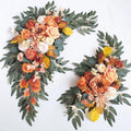 Two artificial arch flower swags with burnt orange, peach and cream roses, mustard leaves and willow greenery