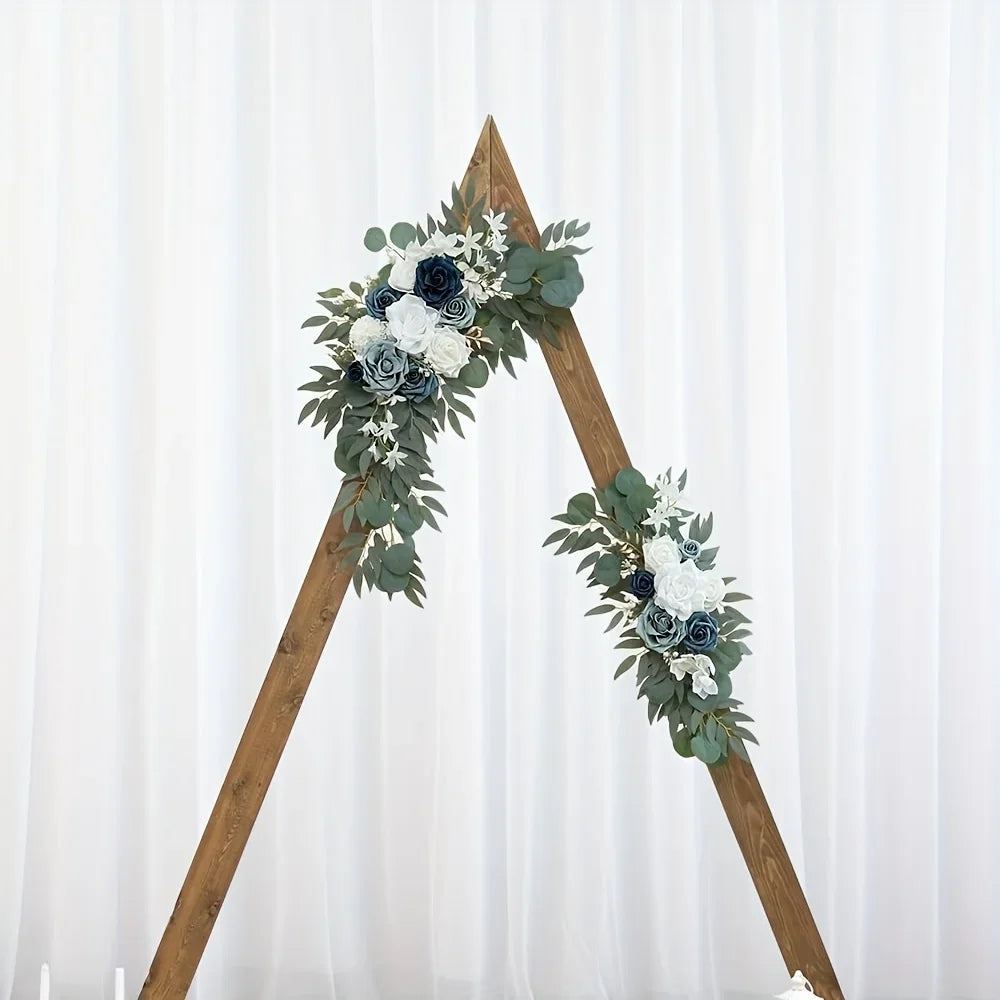 Wooden triangle wedding arch decorated with dusty blue and navy rose swags on two corners