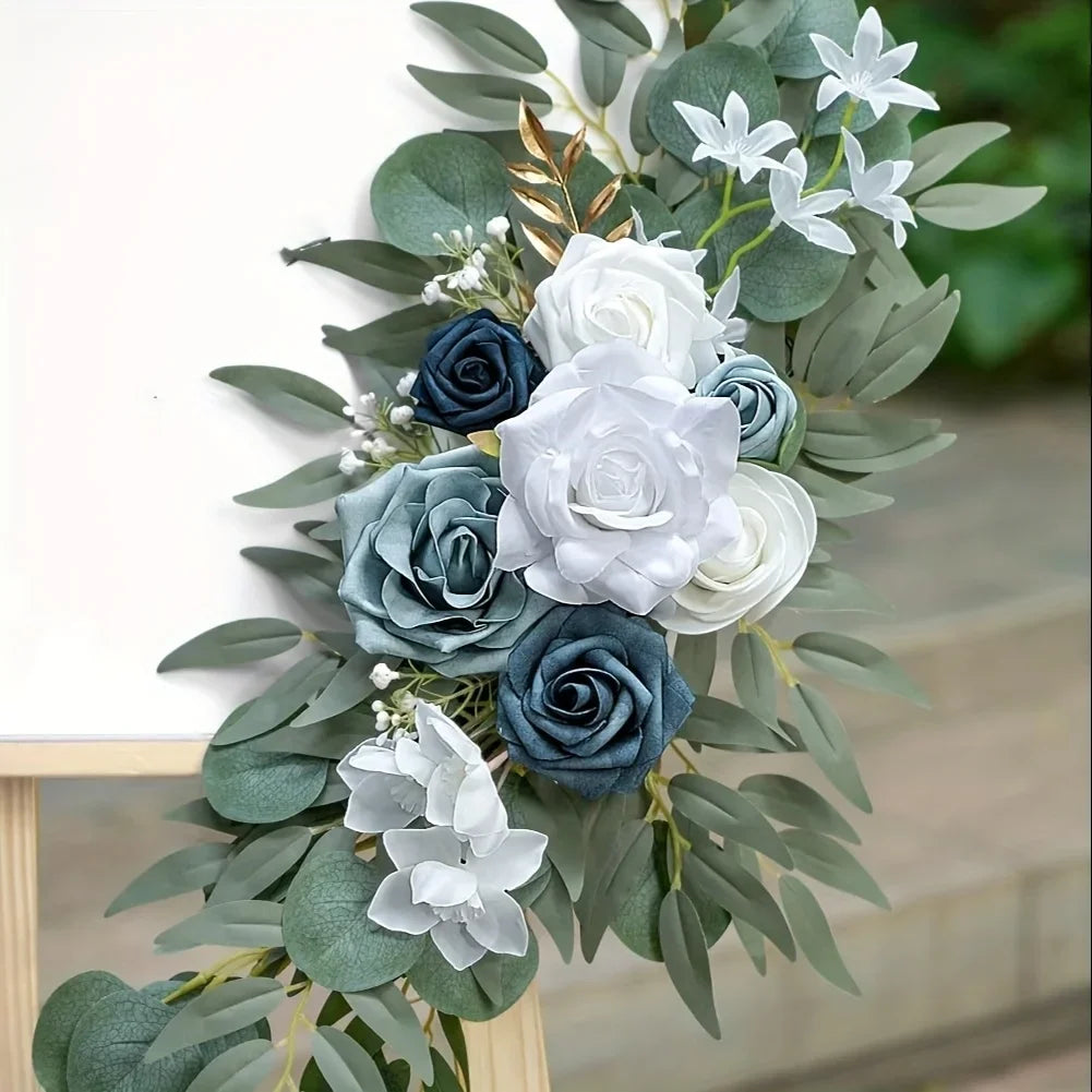 Dusty blue and white rose swag with willow eucalyptus and gold-tipped leaves on a wooden frame
