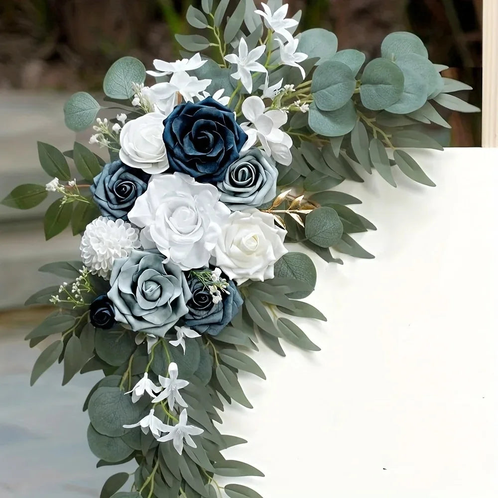 Dusty blue, navy and white faux roses with eucalyptus and white sprays on the corner of a sign