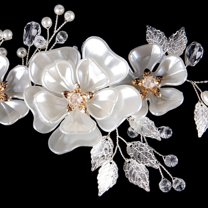 Close-up of pearly white flowers with gold centers, silver leaves, pearls and crystal beads