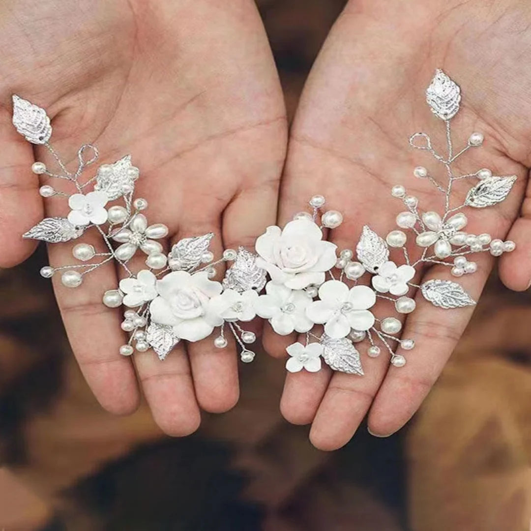 Silver pearl and white flower bridal hair vine resting in two open hands to show its size and shape