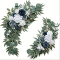 Two artificial floral swags with navy, dusty blue and white roses and eucalyptus greenery on white