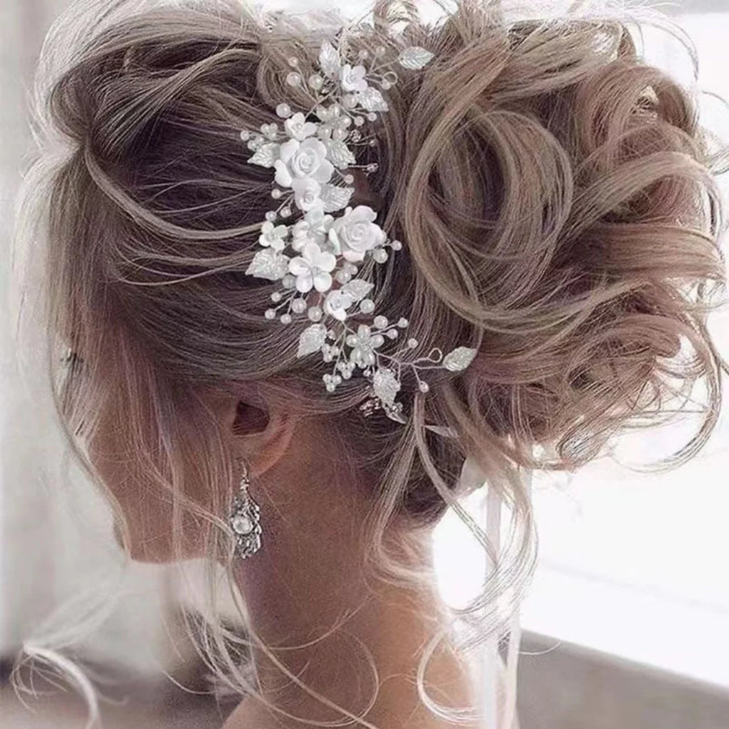 Loose curly bridal updo with a silver pearl and white flower hair vine tucked in at the side