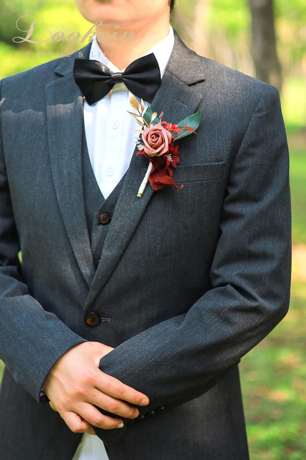 Burgundy groom boutonniere pinned on black suit for rustic wedding ceremony