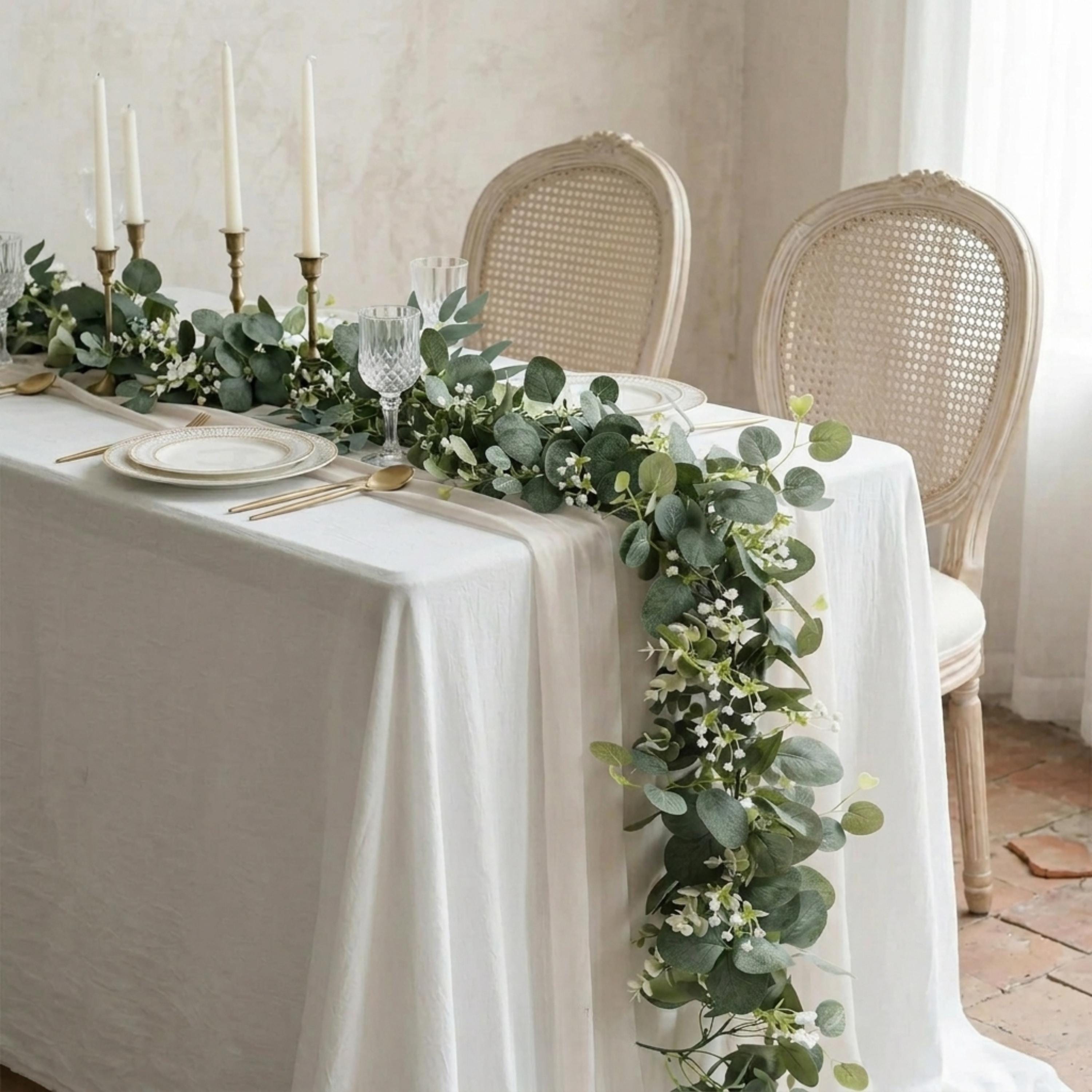 Faux eucalyptus garland with white flowers styled as a wedding table runner