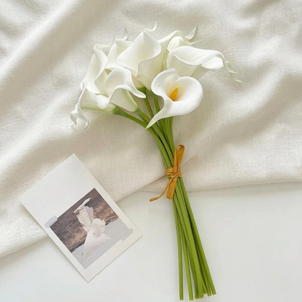 White faux calla lilies styled as a small bridal bouquet for modern wedding decor
