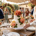 Faux wedding cake flowers styled on a white tiered cake for romantic reception decor