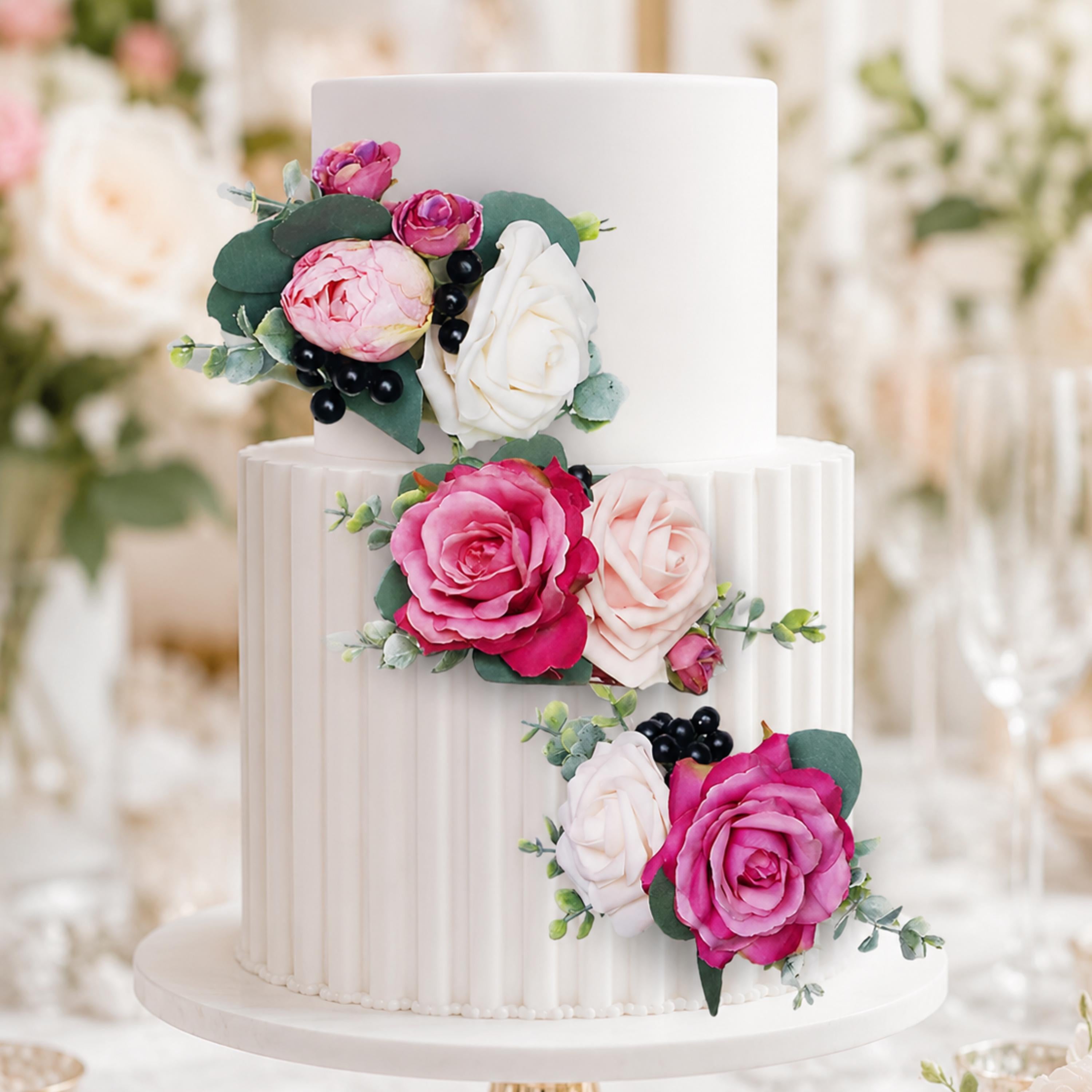 Set of 3 pink wedding cake flowers arranged on a tiered white cake
